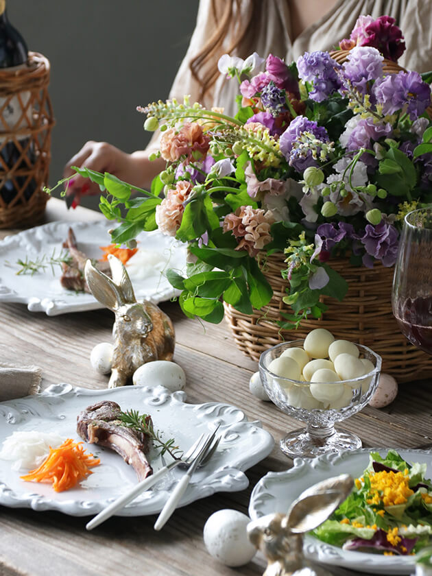 春のむらさきのお花のカゴをイースターのテーブルに飾る
